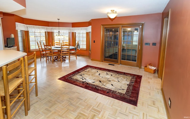 dining room featuring light parquet flooring and an inviting chandelier