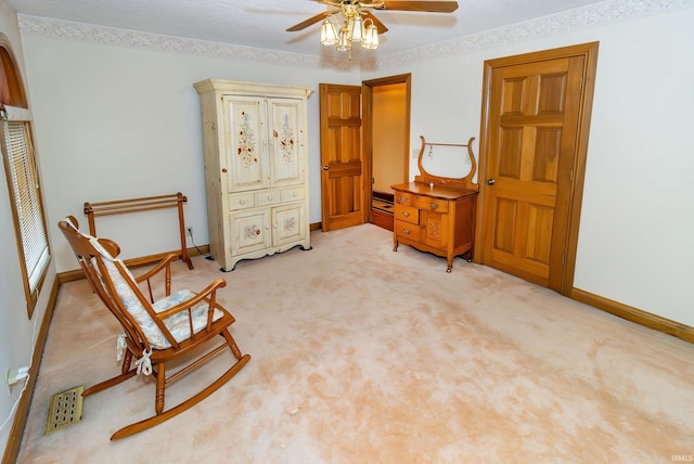 living area with ceiling fan and light colored carpet