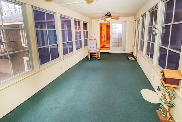 unfurnished sunroom featuring ceiling fan