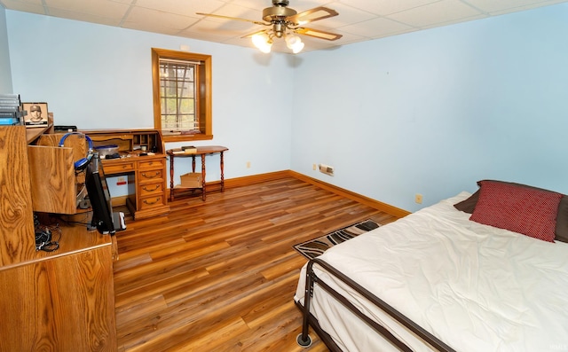 bedroom featuring wood-type flooring, a paneled ceiling, and ceiling fan