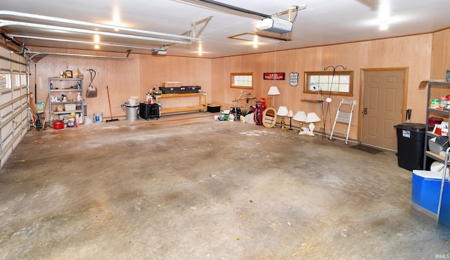 garage with wood walls and a garage door opener