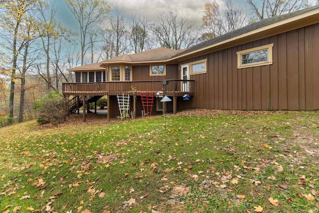 rear view of property with a deck and a lawn