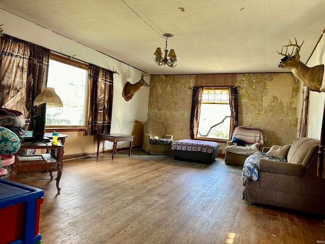 living area with a chandelier, vaulted ceiling, and hardwood / wood-style flooring