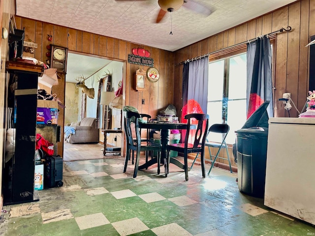 dining room with wood walls and ceiling fan