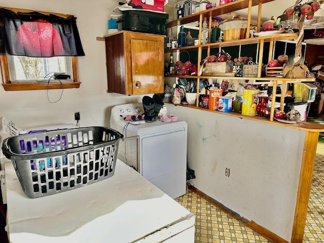 clothes washing area with washer and clothes dryer and cabinets