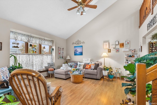 living room with ceiling fan, light hardwood / wood-style flooring, and high vaulted ceiling