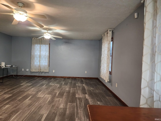 empty room featuring ceiling fan, dark hardwood / wood-style flooring, and a textured ceiling