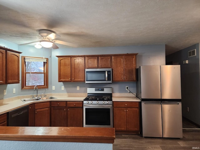 kitchen featuring a textured ceiling, dark hardwood / wood-style floors, sink, and stainless steel appliances