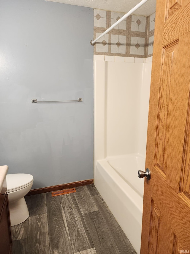 bathroom with hardwood / wood-style floors and toilet