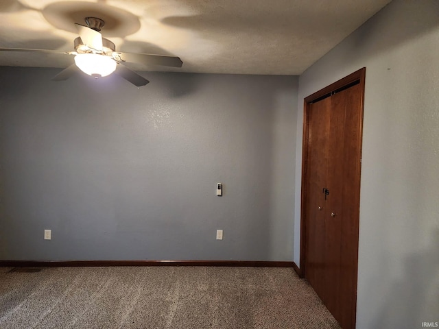 empty room with carpet flooring, ceiling fan, and a textured ceiling