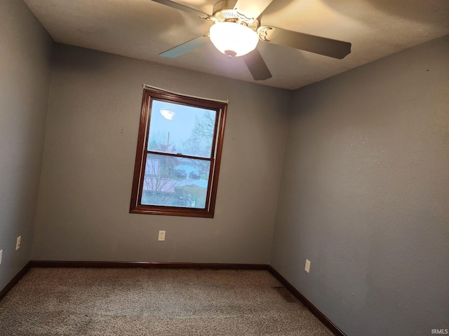 carpeted spare room with ceiling fan