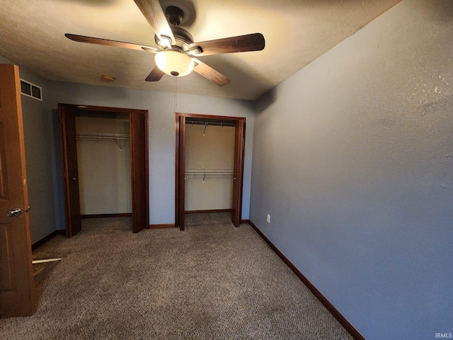 unfurnished bedroom featuring dark carpet and ceiling fan