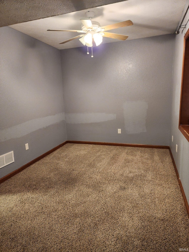 empty room featuring ceiling fan, carpet floors, and a textured ceiling