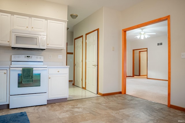 kitchen with ceiling fan, white cabinets, light colored carpet, and white appliances