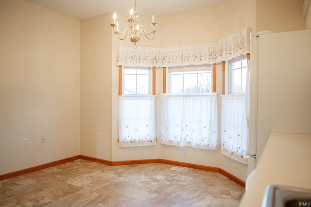 spare room with an inviting chandelier