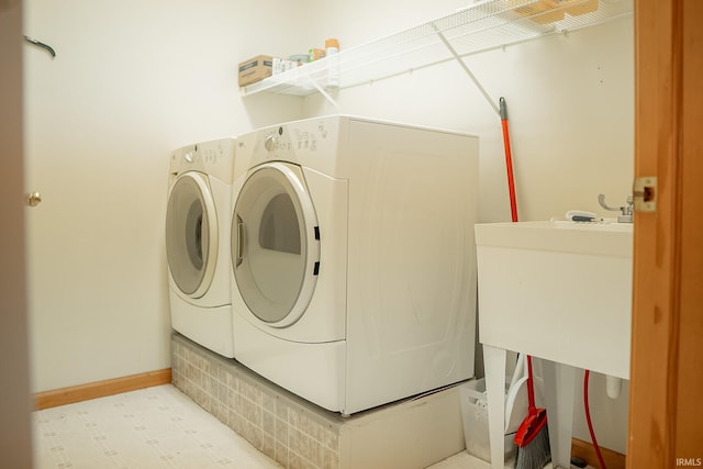 clothes washing area with sink and washer and dryer