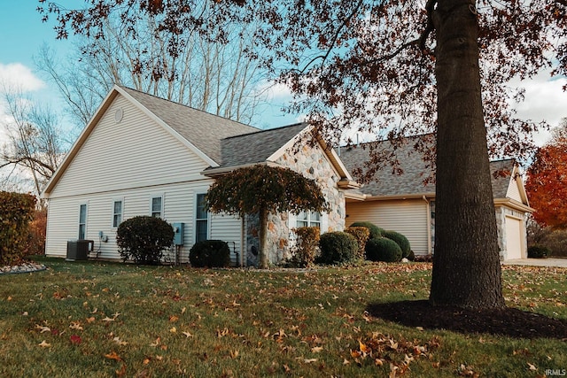 view of side of home featuring a lawn and central AC