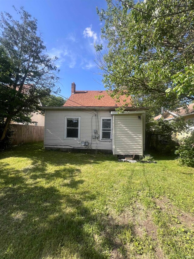 rear view of property with a yard