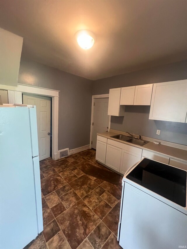 kitchen with white cabinets, white appliances, and sink