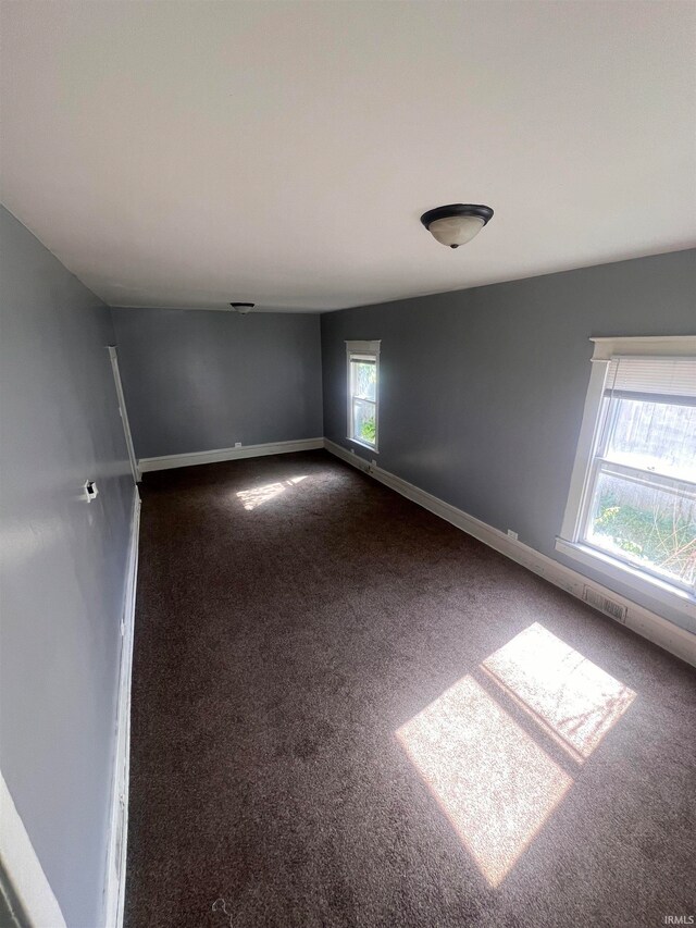 empty room featuring dark carpet