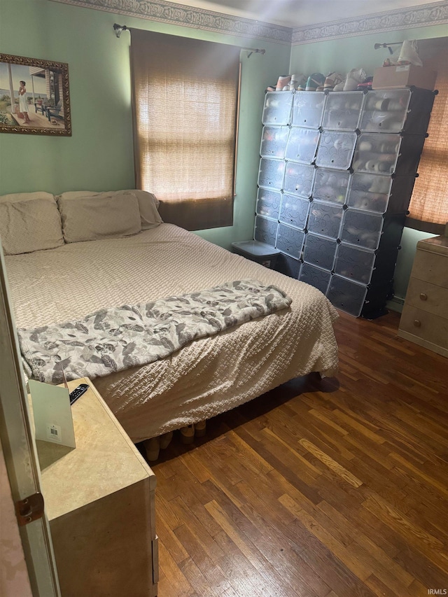 bedroom featuring ornamental molding and dark wood-type flooring