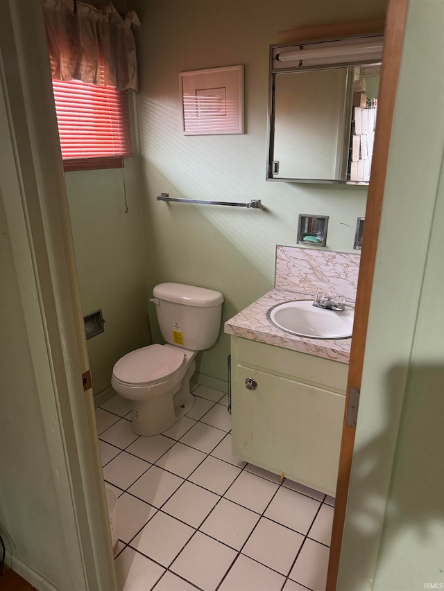 bathroom with tile patterned flooring, vanity, and toilet