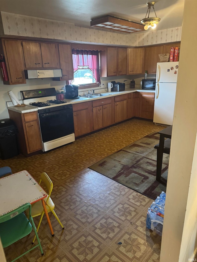 kitchen featuring ventilation hood, white appliances, and sink