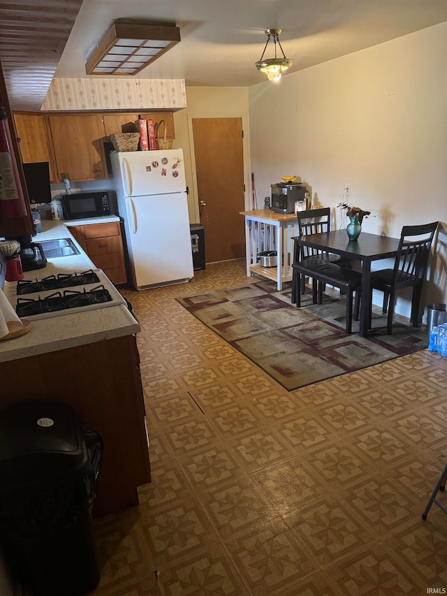 kitchen with decorative light fixtures and white refrigerator