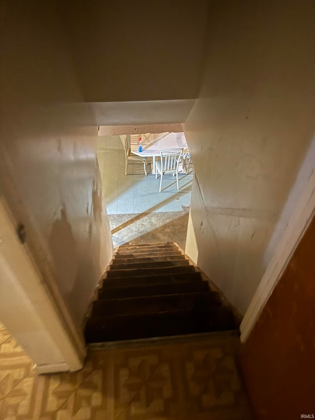 stairs featuring parquet flooring