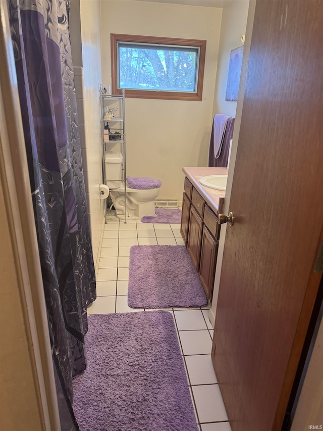 bathroom with toilet, vanity, and tile patterned floors