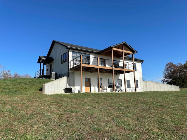 back of property featuring a lawn, a balcony, and central air condition unit