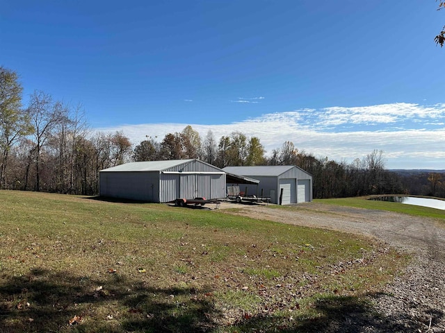 exterior space with a garage, a water view, and a yard