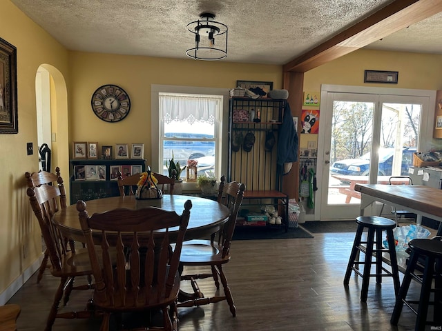 dining area featuring dark hardwood / wood-style floors, a textured ceiling, and a wealth of natural light