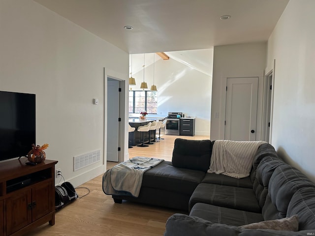 living room featuring light hardwood / wood-style floors and lofted ceiling