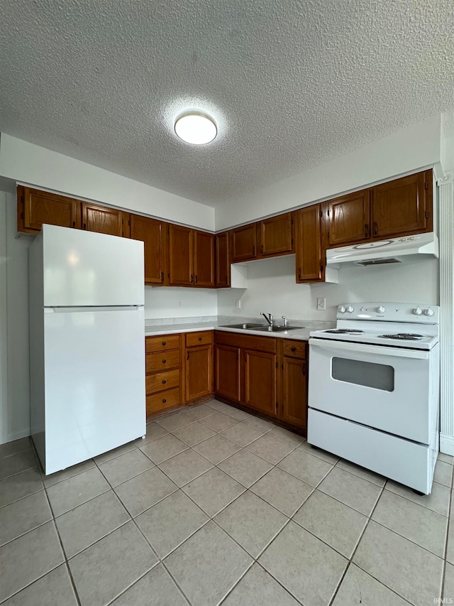 kitchen with a textured ceiling, sink, light tile patterned floors, and white appliances