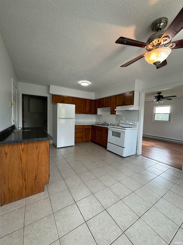 kitchen featuring kitchen peninsula, a textured ceiling, white appliances, light tile patterned floors, and a baseboard radiator