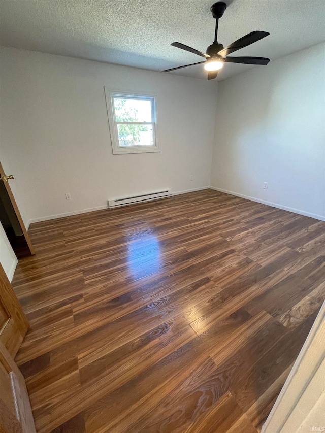 empty room with a textured ceiling, baseboard heating, dark wood-type flooring, and ceiling fan