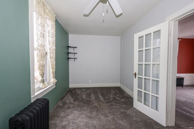 empty room with ceiling fan, radiator heating unit, and dark colored carpet