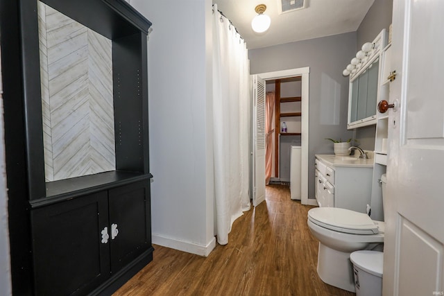 bathroom with hardwood / wood-style floors, vanity, and toilet