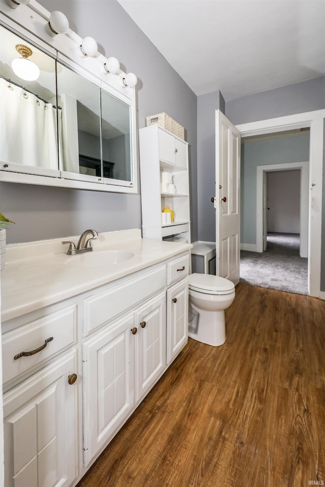 bathroom with hardwood / wood-style floors, vanity, and toilet