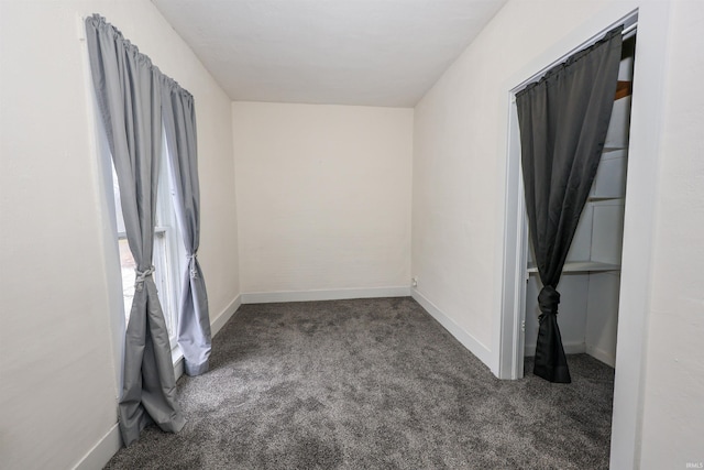 unfurnished room featuring dark colored carpet