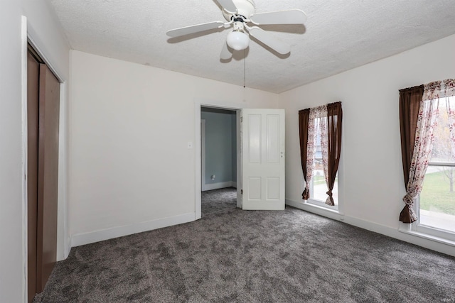 unfurnished bedroom with ceiling fan, a closet, dark carpet, and a textured ceiling