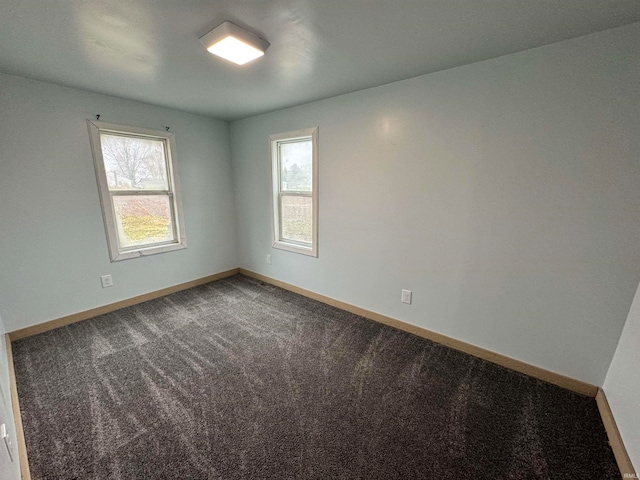 unfurnished room with a wealth of natural light and carpet