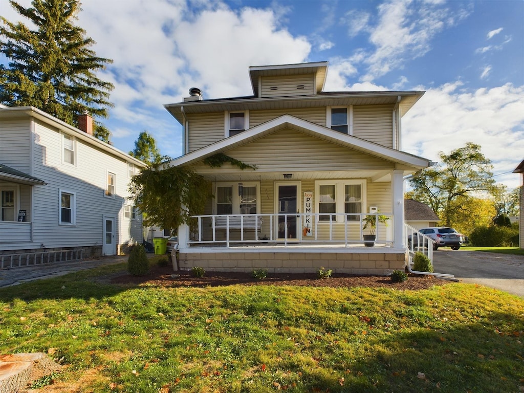 front of property featuring covered porch and a front yard