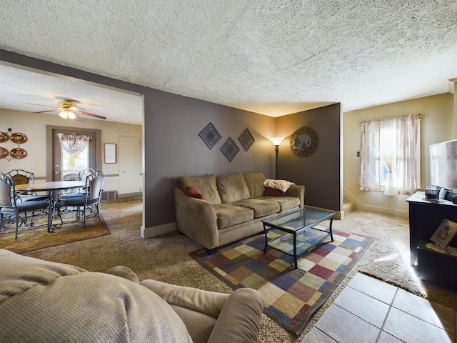 carpeted living room featuring ceiling fan, plenty of natural light, and a textured ceiling