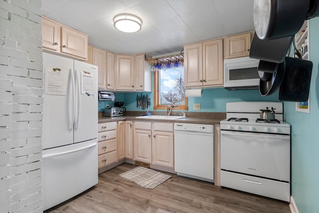 kitchen with light brown cabinets, white appliances, light hardwood / wood-style floors, and sink