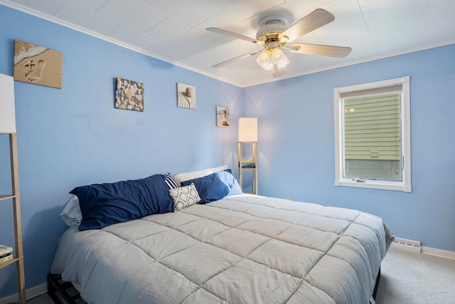 carpeted bedroom featuring ceiling fan, crown molding, and a baseboard heating unit