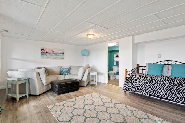 bedroom featuring hardwood / wood-style floors and connected bathroom