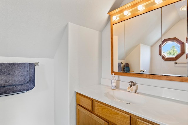 bathroom with vanity and lofted ceiling