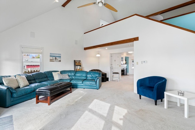 carpeted living room with beamed ceiling, ceiling fan, and high vaulted ceiling